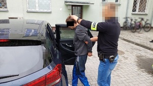 policjant prowadzi zatrzymanego