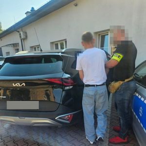 policjant wprowadza mężczyznę do radiowozu