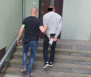 policjant prowadzi zatrzymanego