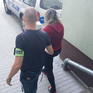 policjant prowadzi zatrzymaną