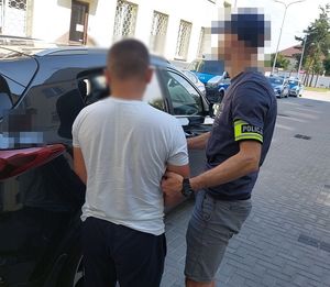 policjant prowadzi zatrzymanego