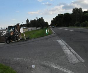miejsca zdarzenia. Skrzyżowanie. Poza drogą stoi motocykl i koparka