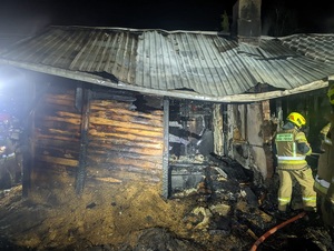 spalony dom. Strażacy w trakcie akcji gaśniczej