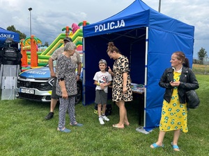 stoisko przy którym stoją uczestnicy festynów