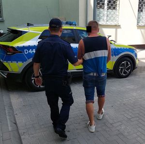 policjant prowadzi zatrzymanego mężczyznę