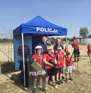 wspólne zdjęcie policjantów i dzieci przed namiotem policyjnym