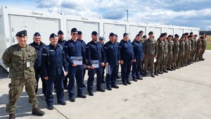 policjanci i żołnierze stoją w dwuszeregu