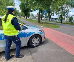 policjantka ruchu drogowego stojąca przy radiowozie z urządzeniem alcoblow