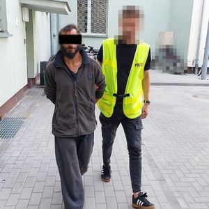 policjant prowadzi zatrzymanego