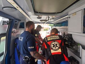 policjant i ratownicy w karetce