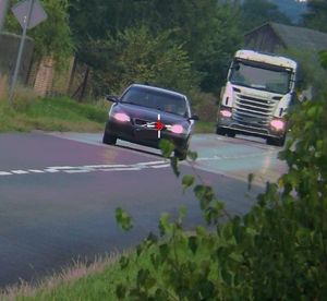 zdjęcie z miernika prędkości. Dwa samochody. Pierwszy osobowy, którego kierowca przekroczył prędkość. Za nim samochód ciężarowy.