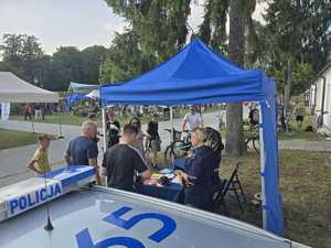 osoby i policjanci przy stoisku