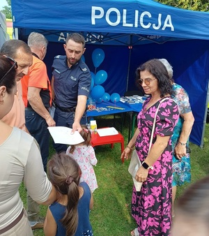 policjant daje dzieciom kolorowanki