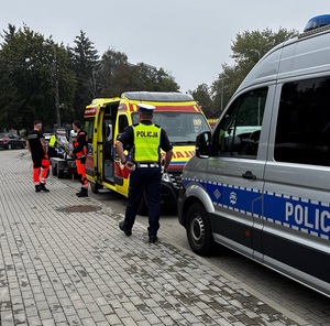policjant i ratownicy medyczni przy autach służb