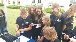 dzieci przy stoisku policyjnym czytają pytanie konkursowe