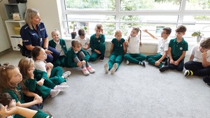 dzieci siedzą z policjantką