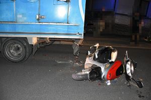 skuter leży obok zaparkowanego samochodu dostawczego