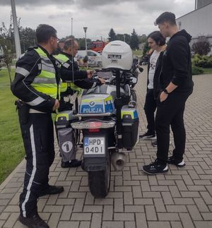 policjanci z osobami oglądającymi motocykle