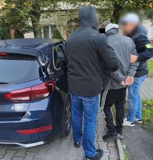 policjanci prowadzą zatrzymanego