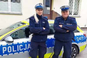 policjanci stoją przy radiowozie