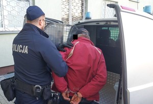 policjant prowadzi zatrzymanego