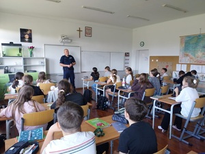 policjant rozmawia z uczniami