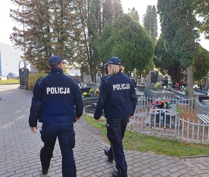 policjanci idą przez cmentarz