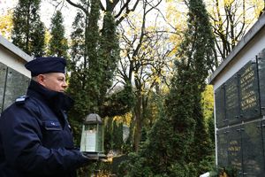 komendant Gil ze zniczem przy pomniku