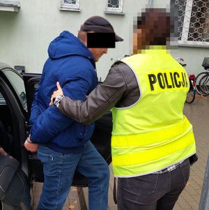 policjantka wyprowadza zatrzymanego z radiowozu