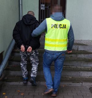 policjant doprowadza zatrzymanego