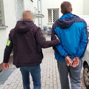 policjant prowadzi zatrzymanego