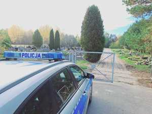 radiowóz stroi przy ogrodzeniu cmentarza