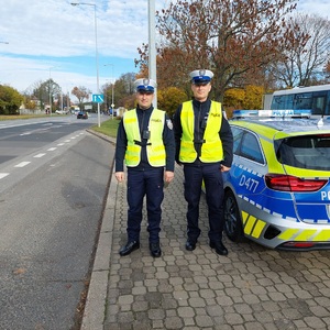policjanci stoją przy radiowozie