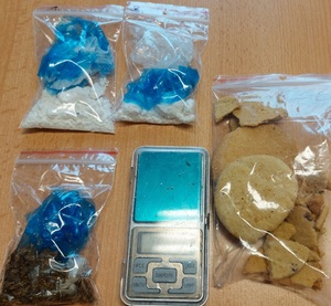 narkotyki i ciastka w woreczkach foliowych obok waga kieszonkowa