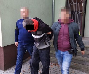 policjanci prowadzą zatrzymanego