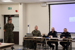 policjanci i żołnierze siedzą przy stole podczas szkolenia