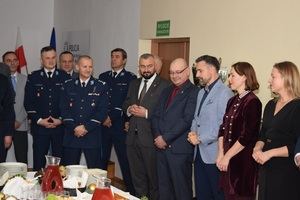 komendant przemawia podczas wigilii. Obok policjanci i zaproszeni goście