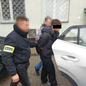 policjanci prowadzą zatrzymanego