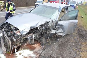 uszkodzony samochód. Policjant wykonuje czynności na miejscu zdarzenia