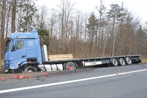 uszkodzona ciężarówka stoi częściowo w rowie.