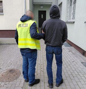 policjant prowadzi zatrzymanego