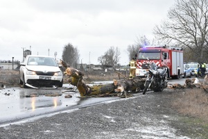 miejsce wypadku uszkodzony samochód służb. Na drodze leży konar