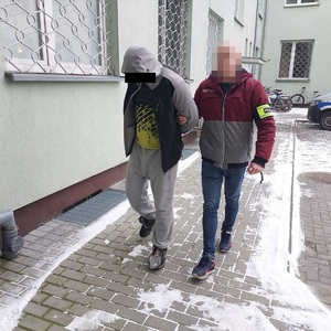 policjant prowadzi zatrzymanego