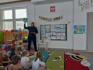policjantka prezentuje dzieciom znaki drogowe