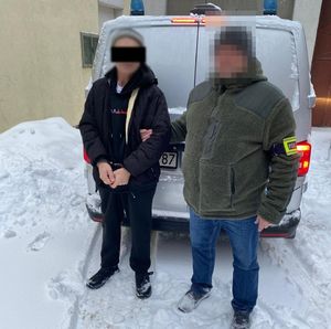 policjant prowadzi zatrzymanego