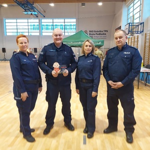 policjanci stoją ze statuetką