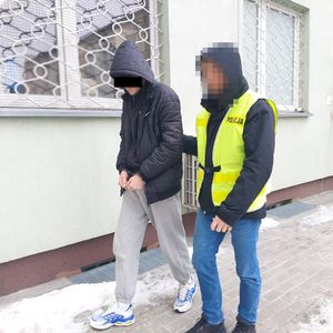 policjant prowadzi zatrzymanego mężczyznę