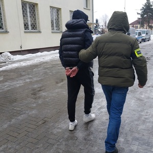 policjant prowadzi zatrzymanego