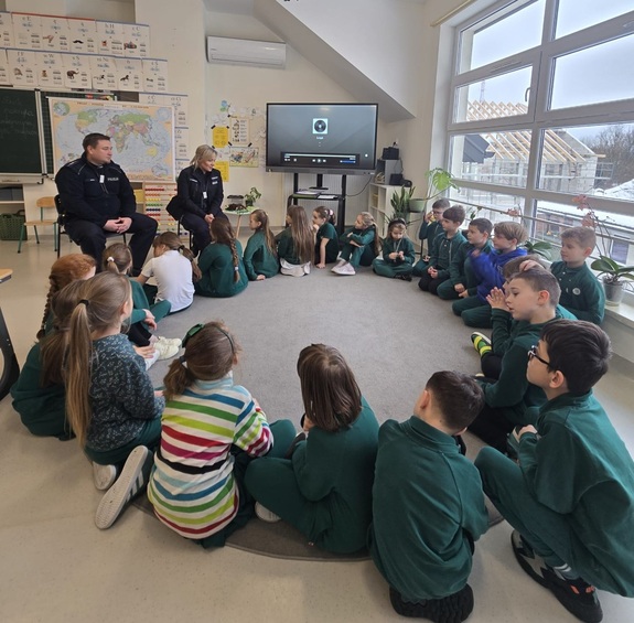 policjanci i dzieci siedzą w kółku