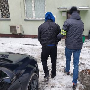 policjant nieumundurowany prowadzi zatrzymanego